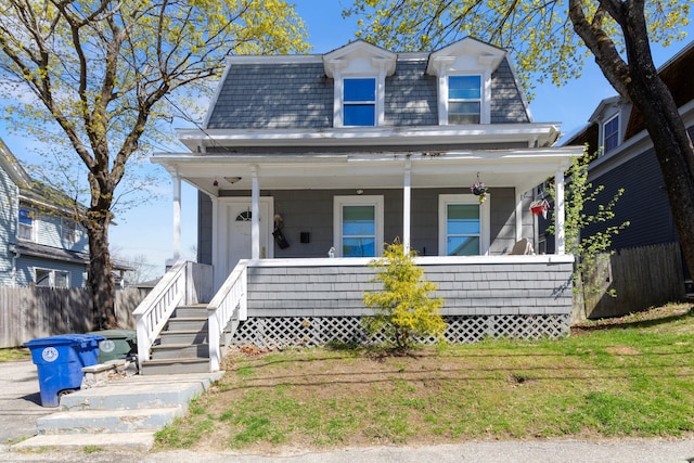 124 Brackett St, Westbrook, ME 04092 - victorian home featuring a porch, fence, and mansard roof