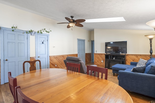 450 W Rd, Waterboro, ME 04087 - dining space featuring vaulted ceiling, a wainscoted wall, wooden walls, a textured ceiling, and a ceiling fan