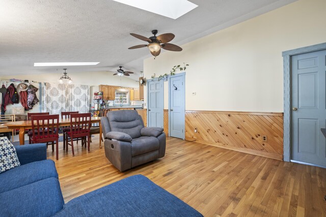 450 W Rd, Waterboro, ME 04087 - living room featuring a skylight, wainscoting, lofted ceiling, light wood-style floors, and ceiling fan