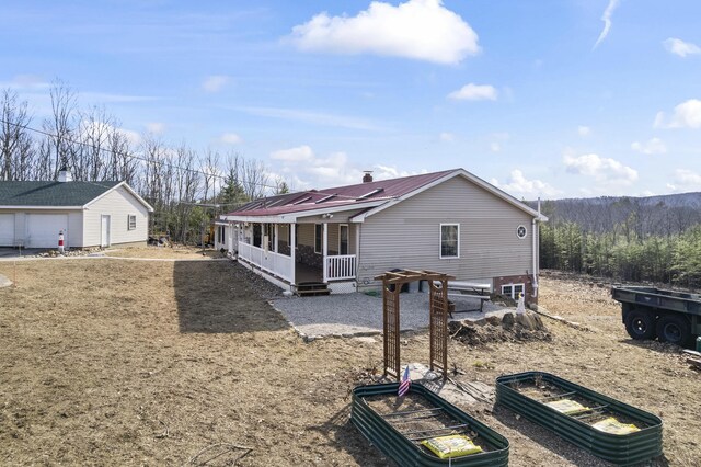 450 W Rd, Waterboro, ME 04087 - rear view of house with a vegetable garden, metal roof, and a detached garage