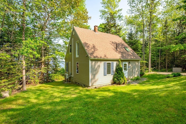 15 Eds Rd, Camden, ME 04843 - view of side of property with a chimney, roof with shingles, and a lawn