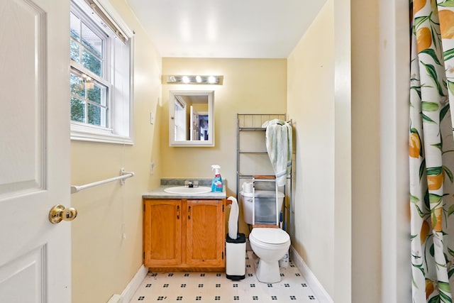 bathroom with tile patterned floors, toilet, baseboards, and vanity