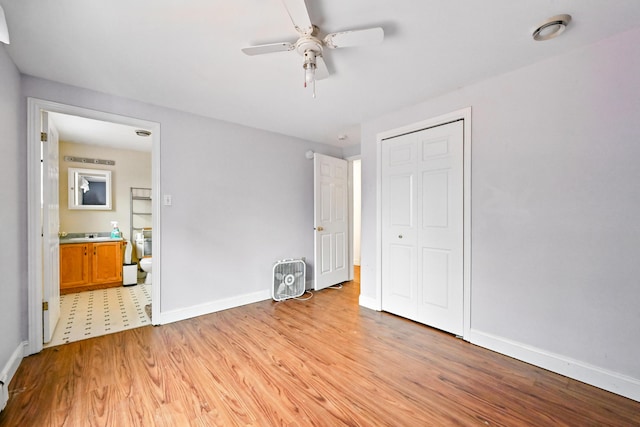 unfurnished bedroom with light wood-type flooring, baseboards, connected bathroom, ceiling fan, and a closet