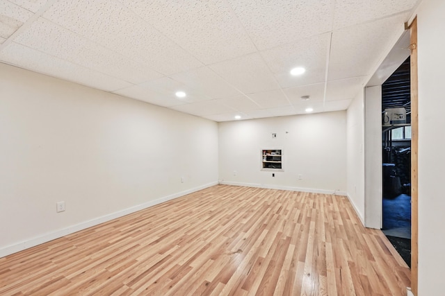 interior space featuring a drop ceiling, baseboards, light wood finished floors, and recessed lighting