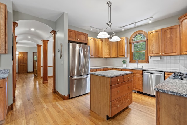 39 Catlin Shore Rd, Harpswell, ME 04079 - kitchen with stainless steel appliances, a sink, decorative columns, arched walkways, and light wood-type flooring