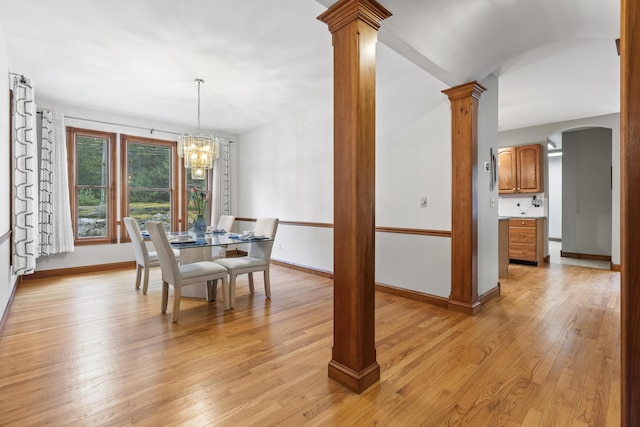 39 Catlin Shore Rd, Harpswell, ME 04079 - dining room featuring light wood-style floors, arched walkways, ornate columns, and a chandelier