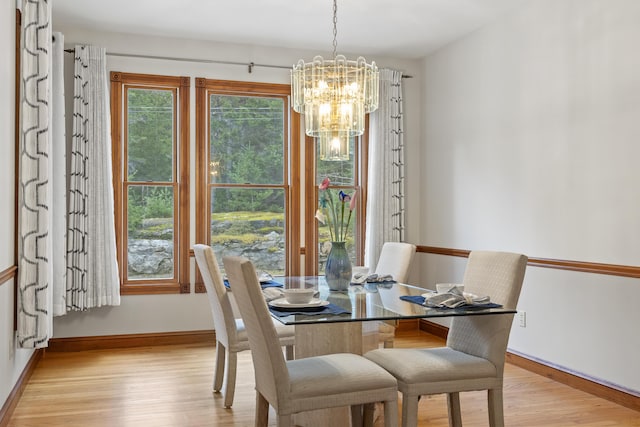 39 Catlin Shore Rd, Harpswell, ME 04079 - dining area with a chandelier, light wood-style flooring, and baseboards