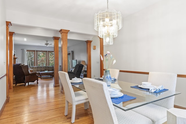 39 Catlin Shore Rd, Harpswell, ME 04079 - dining room featuring ornate columns, light wood-style flooring, and a chandelier