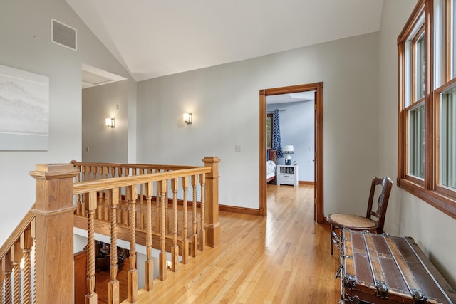 39 Catlin Shore Rd, Harpswell, ME 04079 - hallway with an upstairs landing, vaulted ceiling, light wood-type flooring, and baseboards