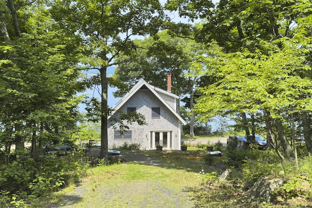 view of side of property with french doors and a chimney