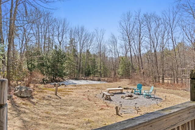 369 Windham Center Rd, Windham, ME 04062 - view of yard featuring an outdoor fire pit and a wooded view