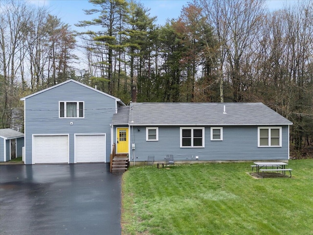 view of front facade featuring driveway, a garage, a front yard, and a shingled roof