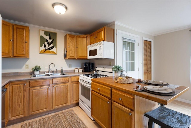 kitchen with white appliances, a sink, a kitchen bar, light wood-style floors, and crown molding