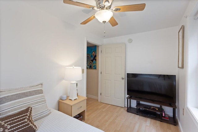 bedroom featuring light wood finished floors, baseboards, and ceiling fan