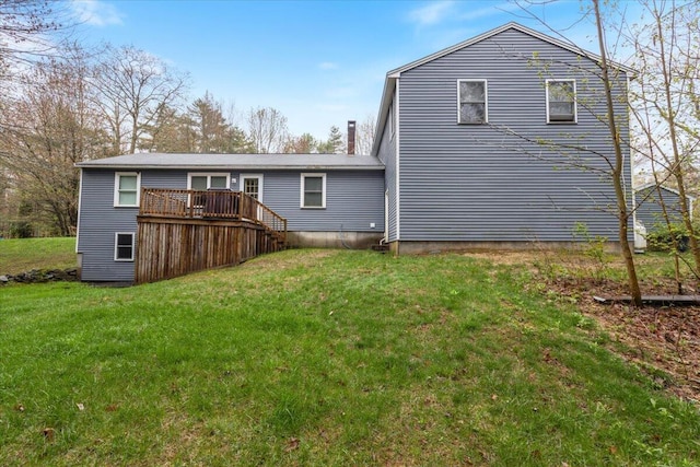 back of property with a deck and a yard