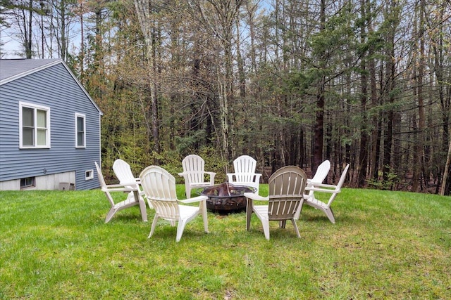 view of grassy yard with an outdoor fire pit