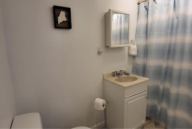 bathroom featuring toilet, vanity, curtained shower, and tile patterned flooring