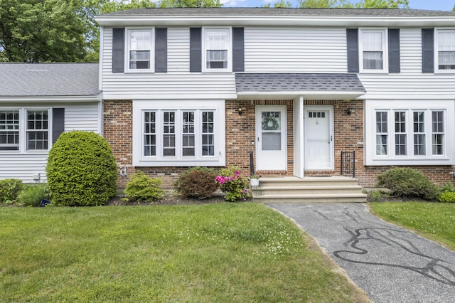 48 Garfield St Unit 7, Saco, ME 04072 - view of front of house with brick siding, a front yard, and roof with shingles