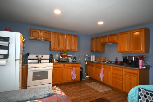 58 Greenwood Ave, Skowhegan, ME 04976 - kitchen featuring white appliances, wood finished floors, a sink, brown cabinetry, and recessed lighting