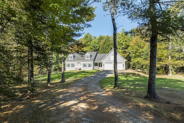 view of front of home featuring dirt driveway, a front lawn, and a garage