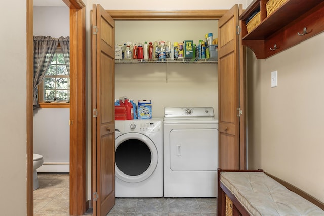 washroom featuring washing machine and dryer, a baseboard heating unit, laundry area, and light tile patterned flooring