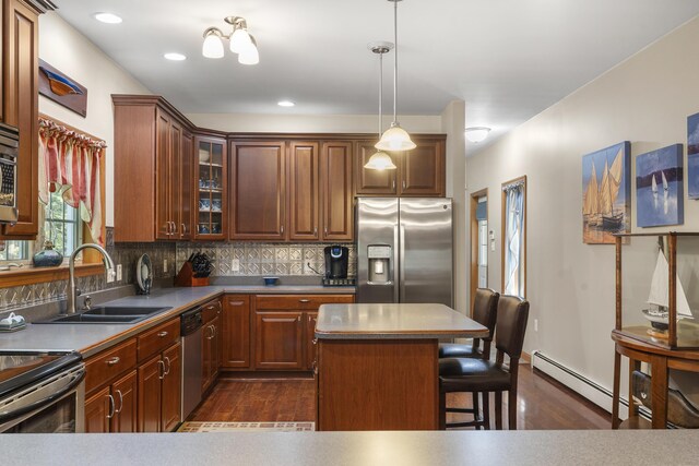 kitchen with glass insert cabinets, a breakfast bar, baseboard heating, a sink, and stainless steel appliances