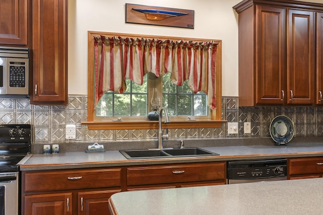 kitchen featuring appliances with stainless steel finishes, decorative backsplash, a sink, and dark countertops
