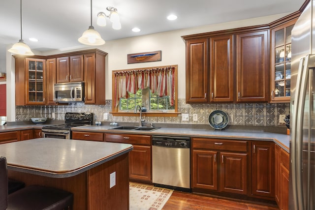 kitchen featuring a sink, dark countertops, dark wood-style flooring, and stainless steel appliances