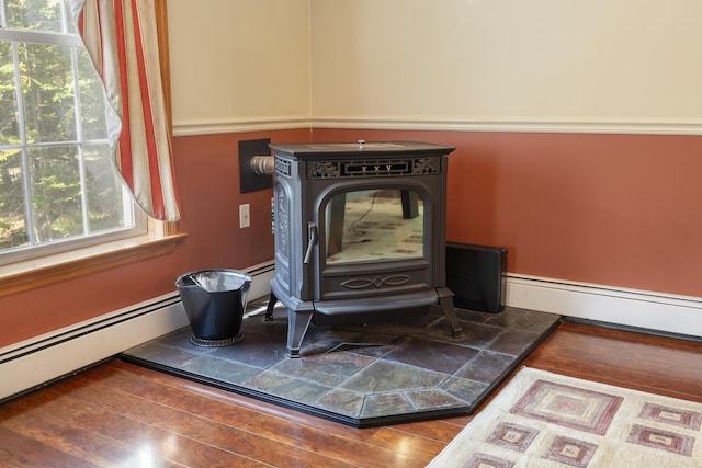 details with a baseboard radiator, wood finished floors, and a wood stove