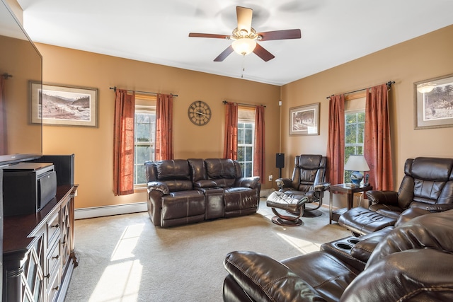 living area featuring carpet floors, a ceiling fan, plenty of natural light, and a baseboard heating unit