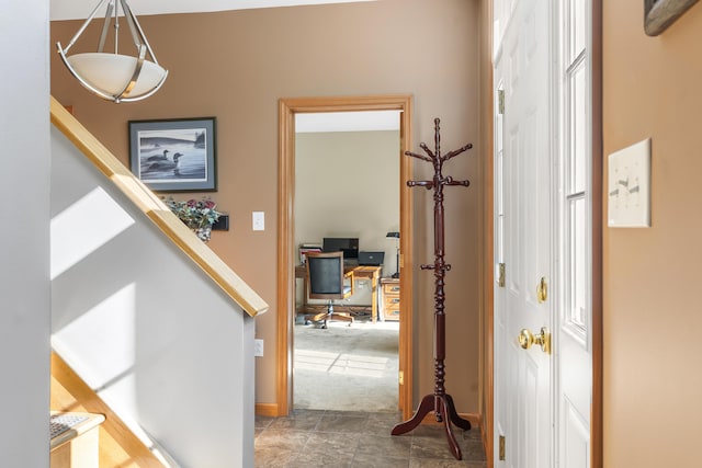 hallway with stairway and baseboards
