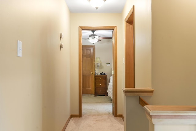 corridor with light colored carpet and baseboards