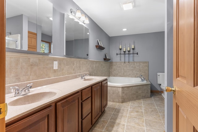 bathroom with toilet, a garden tub, a sink, and tile patterned flooring