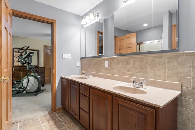 bathroom featuring tile patterned floors, double vanity, tile walls, and a sink