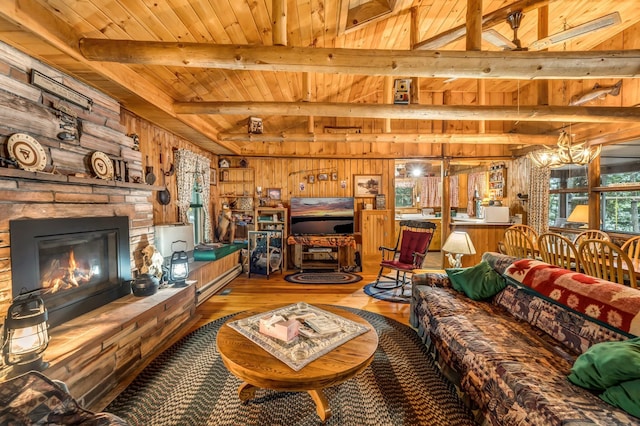 32 Seymour Cove Rd, Bowerbank, ME 04426 - living room with a wood ceiling with exposed beams, wood walls, hardwood / wood-style flooring, a chandelier, and a glass covered fireplace