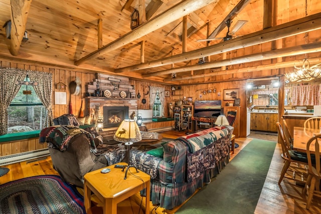 32 Seymour Cove Rd, Bowerbank, ME 04426 - living room with wood walls, a wooden ceiling with exposed beams, wood-type flooring, a stone fireplace, and baseboard heating
