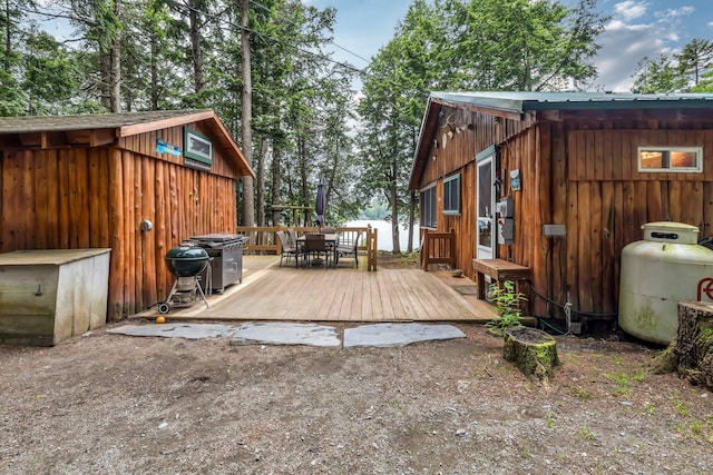 32 Seymour Cove Rd, Bowerbank, ME 04426 - deck with outdoor dining space, a grill, and an outdoor structure