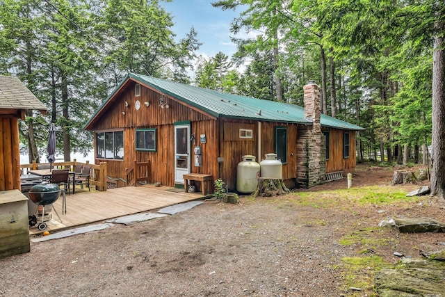 32 Seymour Cove Rd, Bowerbank, ME 04426 - back of property with a wooden deck, a metal roof, and a chimney