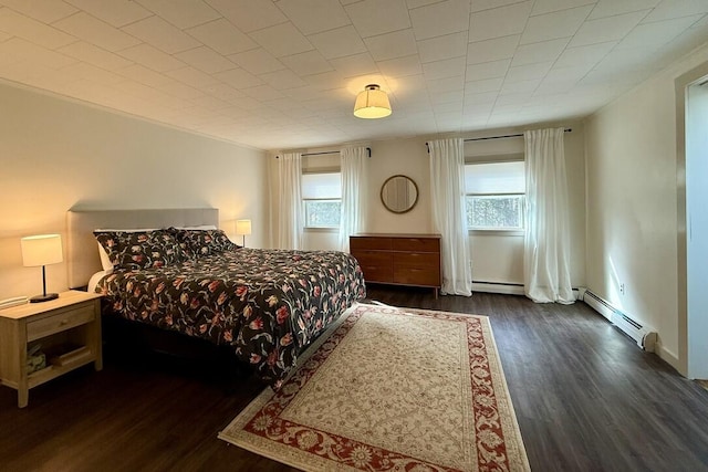 bedroom with baseboard heating and dark wood finished floors