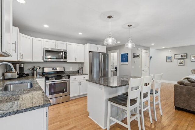 33 Old Dynamite Way, Gorham, ME 04038 - kitchen with stainless steel appliances, a sink, recessed lighting, a breakfast bar, and white cabinets