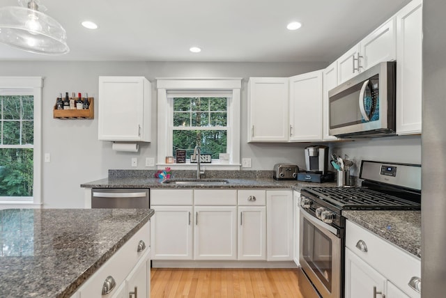 33 Old Dynamite Way, Gorham, ME 04038 - kitchen featuring appliances with stainless steel finishes, a sink, white cabinetry, dark stone counters, and light wood-type flooring