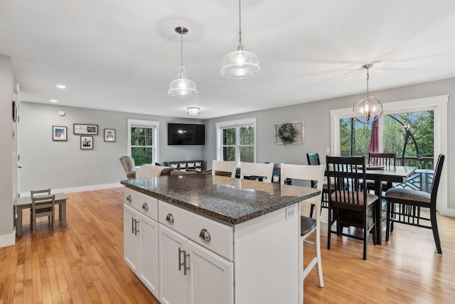 33 Old Dynamite Way, Gorham, ME 04038 - kitchen with a breakfast bar area, a kitchen island, light wood-style flooring, a chandelier, and recessed lighting