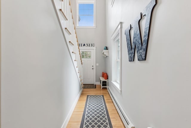 33 Old Dynamite Way, Gorham, ME 04038 - doorway with a baseboard heating unit, baseboards, light wood-style flooring, stairs, and plenty of natural light