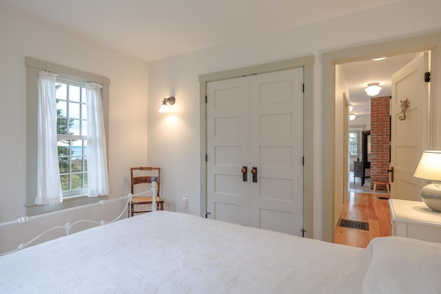421 Petitmanan Point Rd, Steuben, ME 04680 - bedroom featuring a closet, a wood stove, and light wood-type flooring