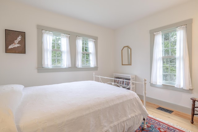 421 Petitmanan Point Rd, Steuben, ME 04680 - bedroom with wood finished floors, baseboards, and heating unit