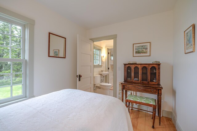 421 Petitmanan Point Rd, Steuben, ME 04680 - bedroom with light wood-type flooring, connected bathroom, and baseboards
