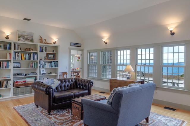 421 Petitmanan Point Rd, Steuben, ME 04680 - living area with plenty of natural light, light wood finished floors, lofted ceiling, and baseboards