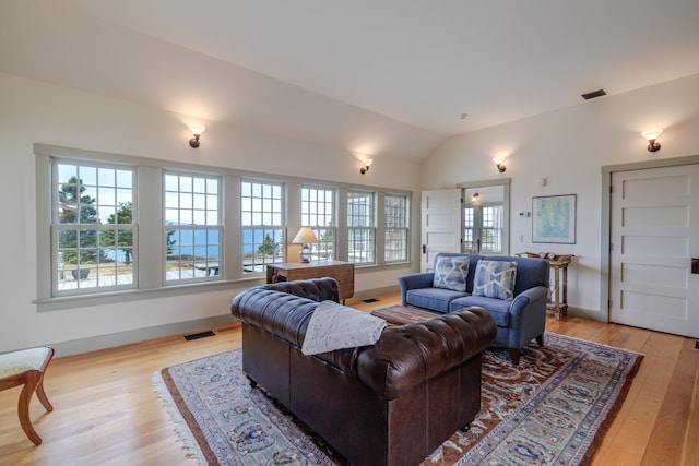421 Petitmanan Point Rd, Steuben, ME 04680 - living room with light wood-style floors, vaulted ceiling, and baseboards