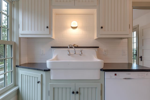 421 Petitmanan Point Rd, Steuben, ME 04680 - kitchen featuring dishwasher, dark countertops, a sink, backsplash, and healthy amount of natural light