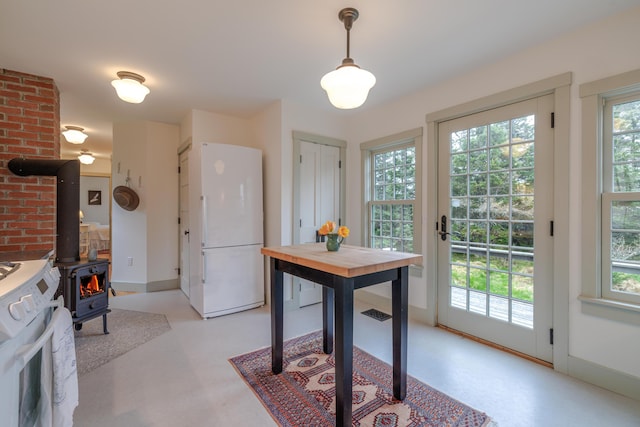 421 Petitmanan Point Rd, Steuben, ME 04680 - kitchen featuring freestanding refrigerator, stove, a wood stove, baseboards, and decorative light fixtures
